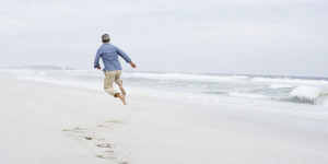 man jumping on the beaches of north carolina for pine forest plantation
